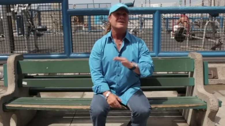 Tony Little in a blue shirt and cap seated on a park bench