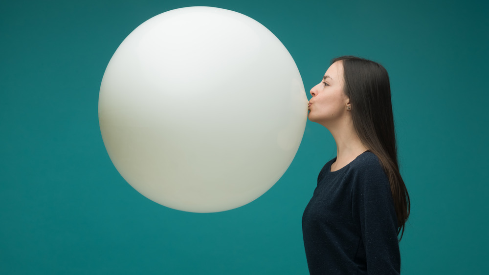 Woman blowing up giant balloon