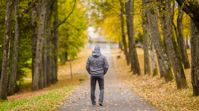 Man walking down wooded road