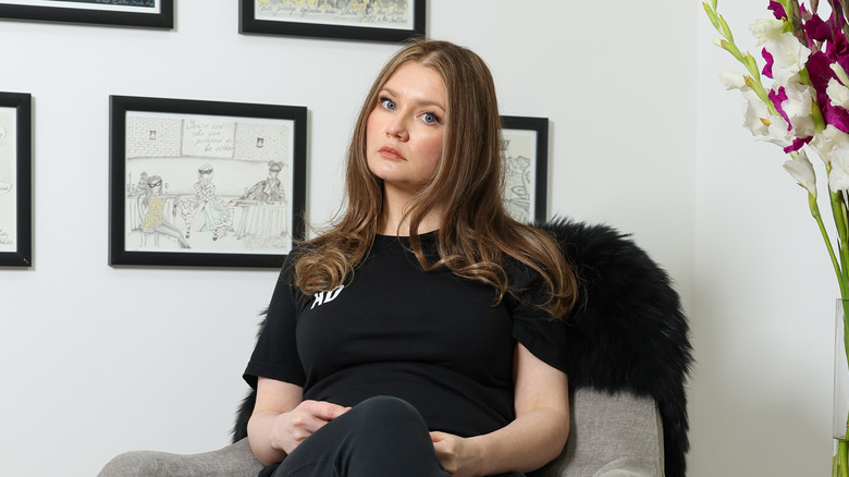 Anna Delvey seated in her apartment