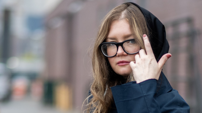 Anna Delvey in hood and glasses