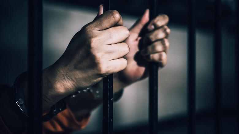 Man in prison holding bars