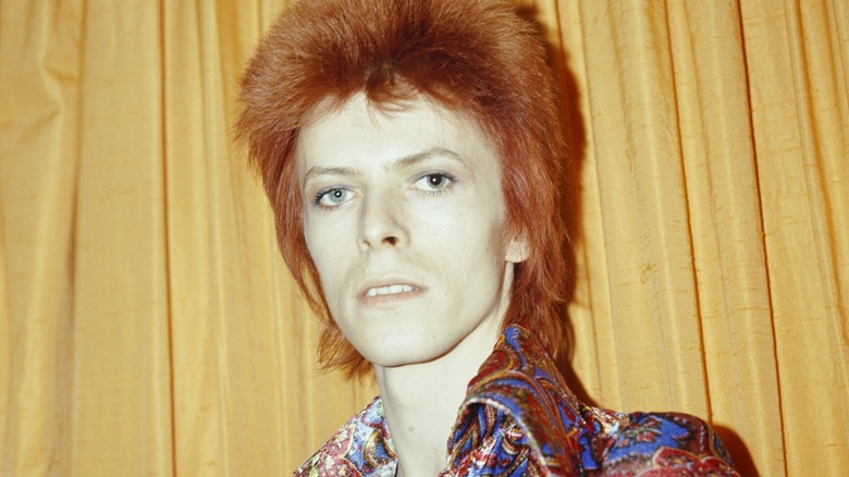 David Bowie as Ziggy Stardust red hair yellow curtain behind