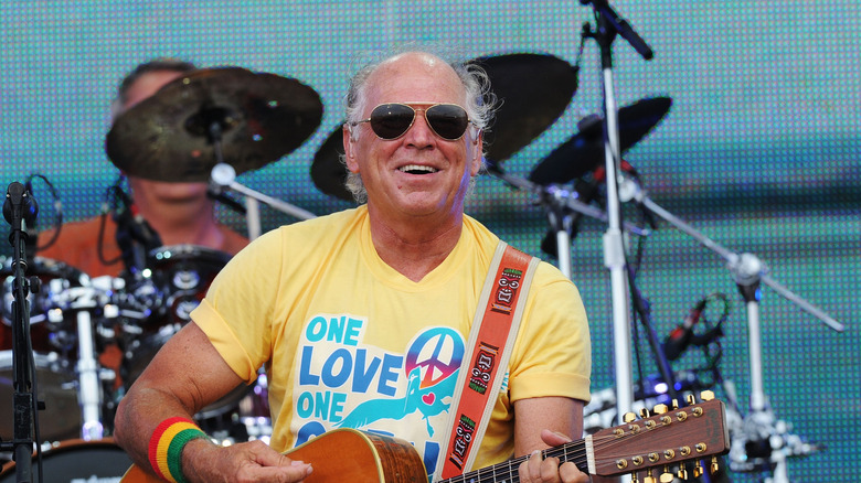 jimmy buffett playing on stage in front of the ocean