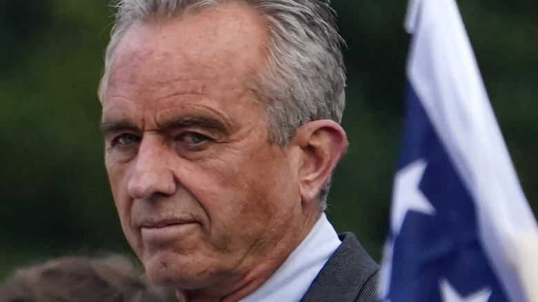 Robert Kennedy Jr. looking thoughtful with American flag 