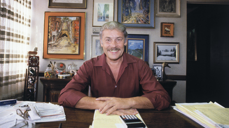 Jerry Buss smiling at his desk