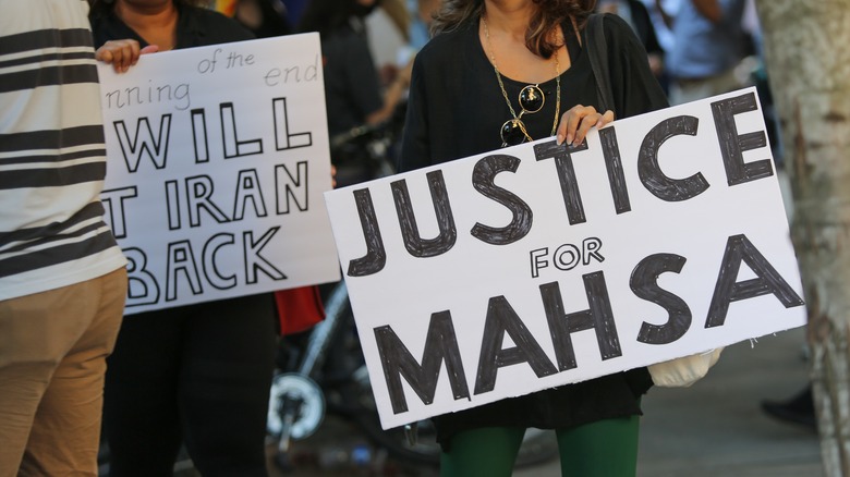 woman holding justice for Mahsa sign