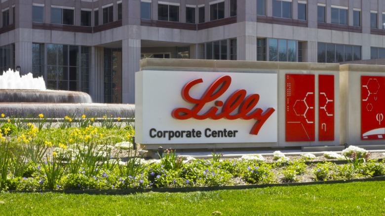 Red Eli Lilly company sign in grass by office