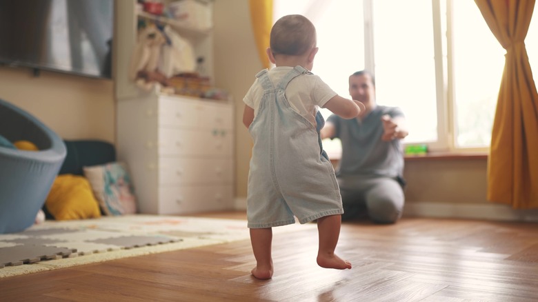 Baby walking to parent