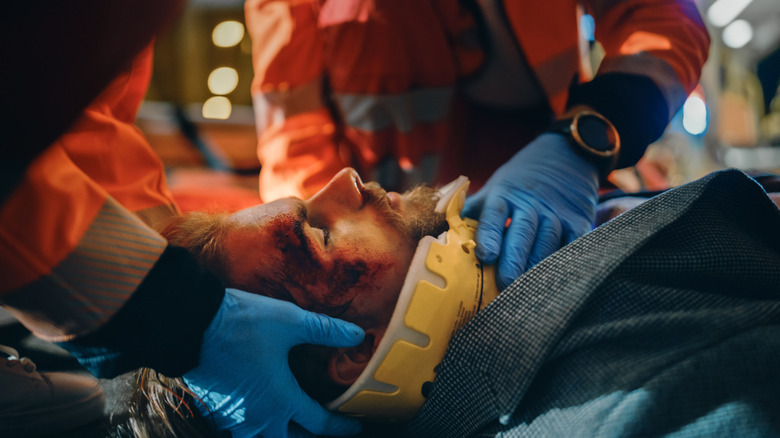 team of paramedics attend to someone with a broken neck