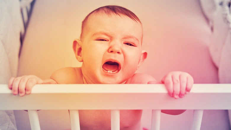 Baby crying alone in crib