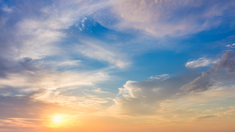 Sun beaming among wispy cloud