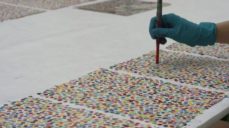 An assistant working on a Damien Hirst spot painting