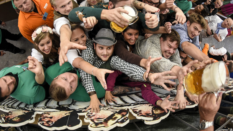 Oktoberfest attendees reaching for beer