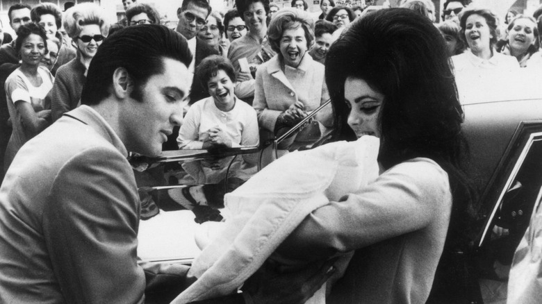 Elvis and Priscilla Presley holding their daughter, Lisa Marie Presley