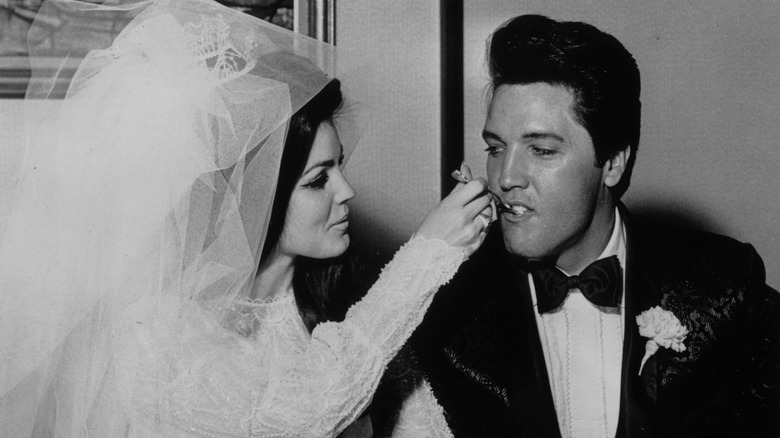 Priscilla Presley feeding Elvis Presley cake at their wedding