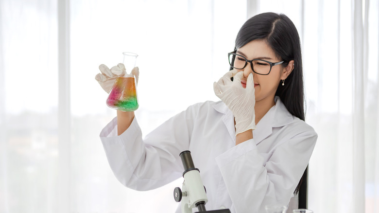 Female scientist smells solution