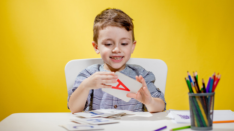 child playing with letter flashcards