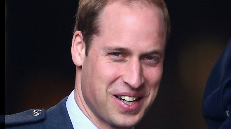 Prince William smiling dark background