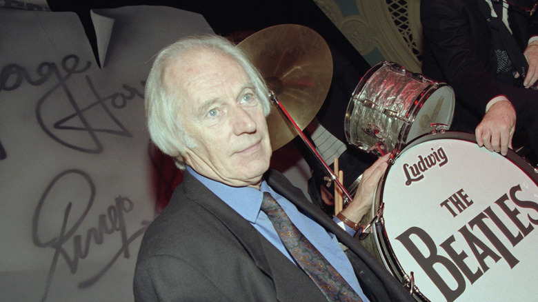 George Martin touching Beatles bass drum