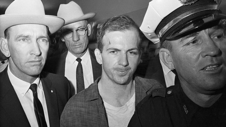 lee harvey oswald with police escorts after arrest