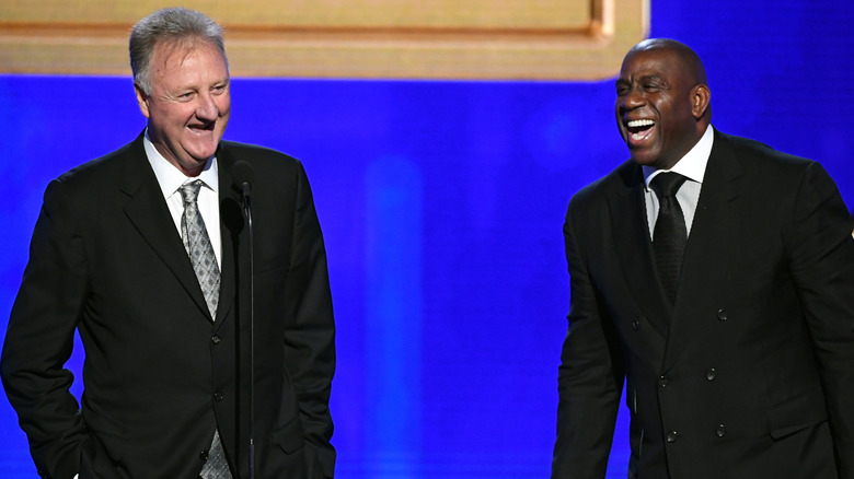 Larry Bird and Magic Johnson laughing on stage 