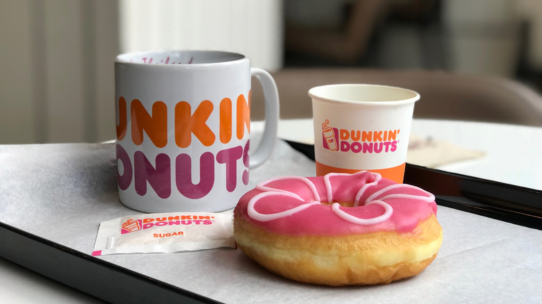 Dunkin' Donuts mug and cup with donut on table