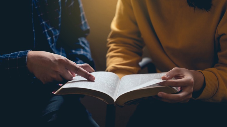 Person pointing to Bible