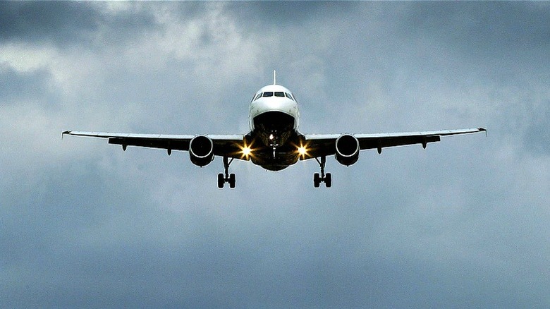 Plane approaches against cloudy skies