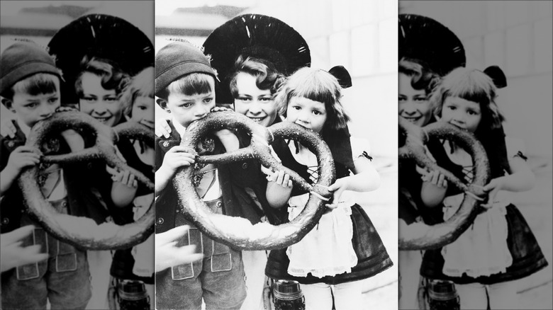 Two children women posing giant pretzel