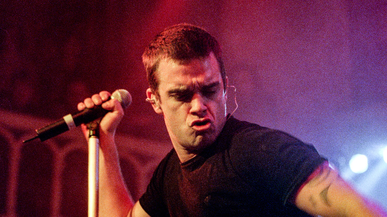 Robbie Williams on stage with microphone