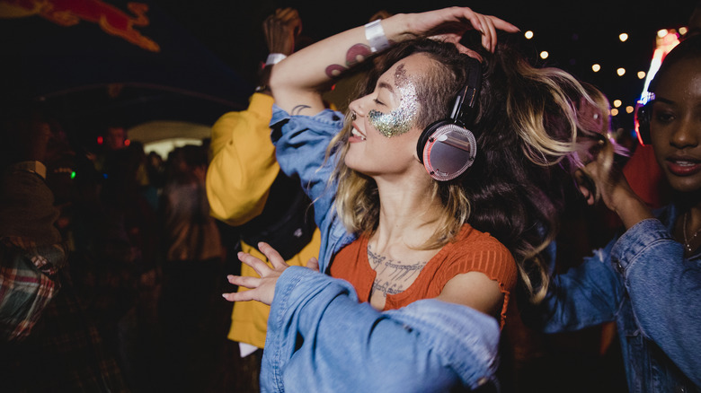 Woman in glitter dancing with headphones