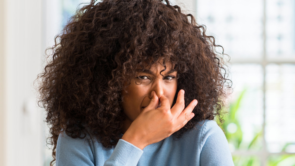 Woman holds her nose