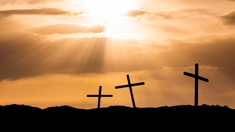 Three crosses silhouetted against setting sun