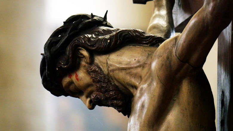 Closeup of sculpted, painted wood head of Jesus on cross