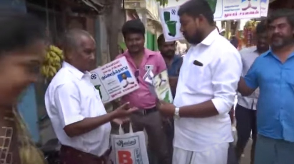 Thulam Saravanan campaigning with flyers