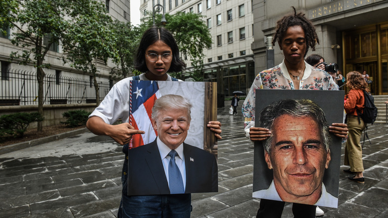 protesters holding photos of Jeffrey Epstein and Donald Trump