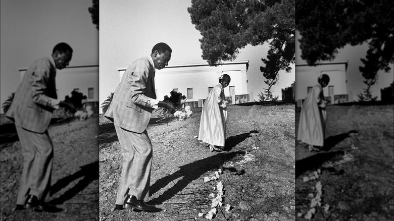 Couple laying flowers at Jonestown victim's grave