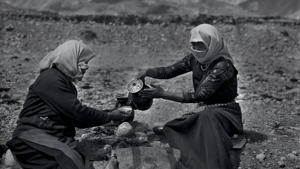 Tibetan women who sell milk tea to truck drivers rest by the road