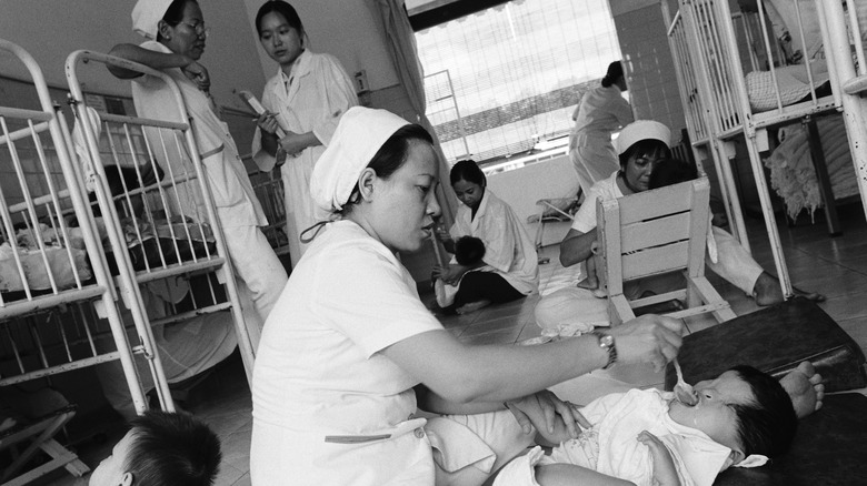 nurses feeding children with birth defects