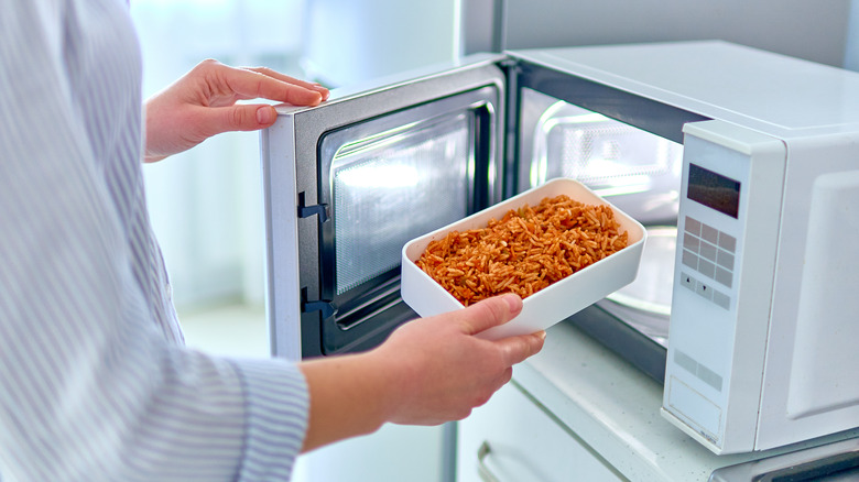 hands placing food into microwave