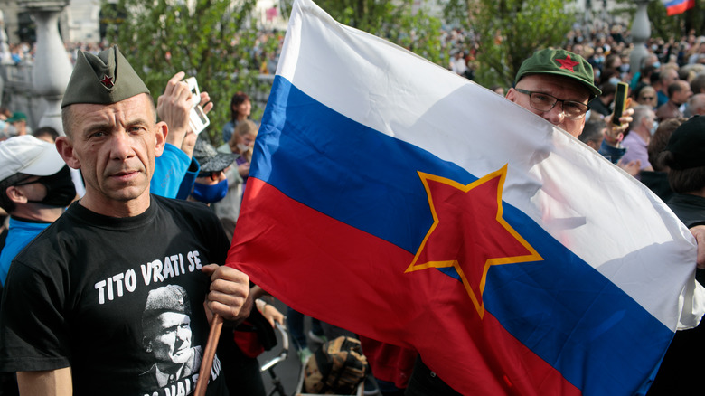 Man holding flag of Yugoslavia