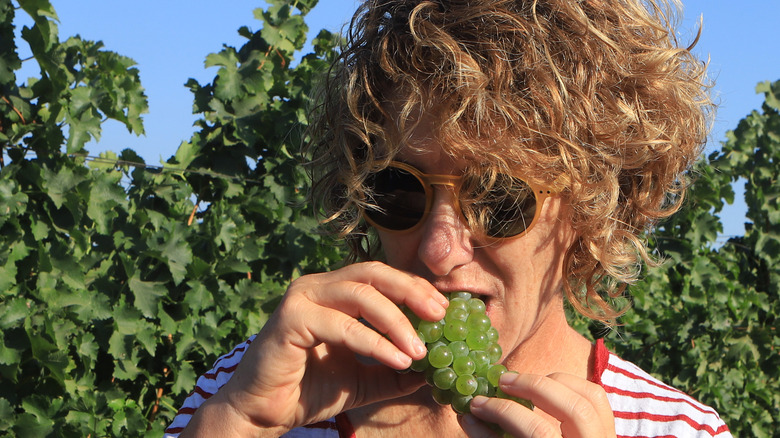 a person eating grapes