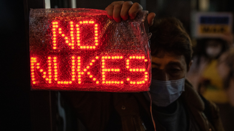 Man holds No Nukes sign near Russian embassy