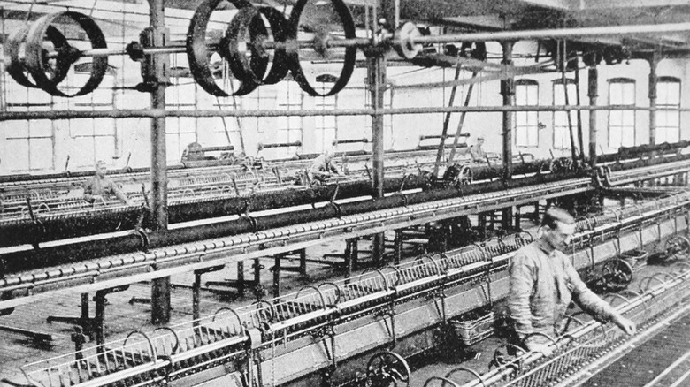 Photograph of a worker and machines spinning woolen warn