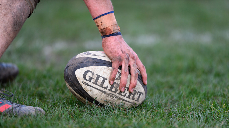 Player holding Gilbert Rugby ball