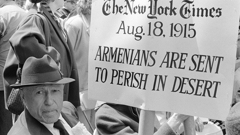 Man holding sign commemorating Armenian genocide