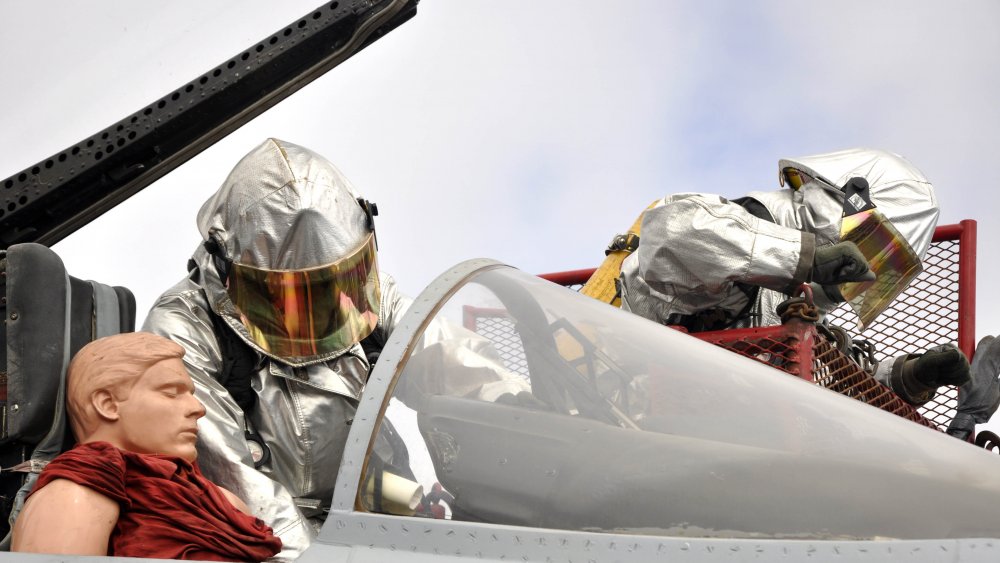 U.S. Sailors assigned to the crash and salvage team remove a training dummy pilot from a simulated downed F-18 trainer during flight deck drills on board the aircraft carrier USS Ronald Reagan (CVN 76) while under way in the Pacific Ocean Oct. 18, 2011