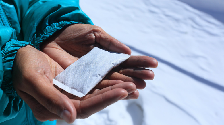 Hands holding disposable hand warmer