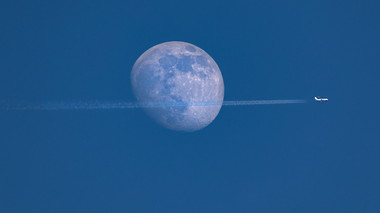 Plane flying in front of the moon